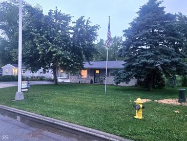 Ranch home with large front yard, mature trees, and American flag at 9470 N Old Port Royal, Martinsville, IN 46151