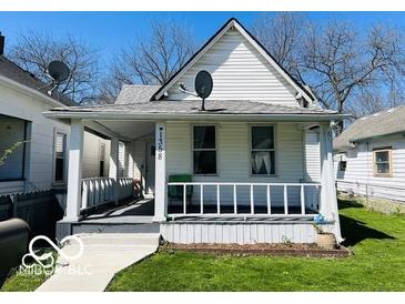 Charming house featuring a covered front porch and a well-maintained lawn at 1358 Hiatt St, Indianapolis, IN 46221