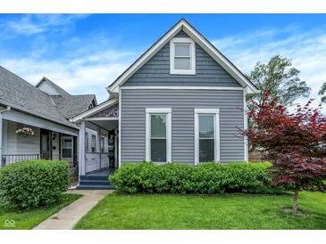 Charming gray two-story home featuring a well-maintained lawn and manicured landscaping at 1531 English Ave, Indianapolis, IN 46201
