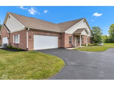 Beautiful brick home featuring an attached two car garage and manicured lawn at 4295 Washington Blvd, Plainfield, IN 46168