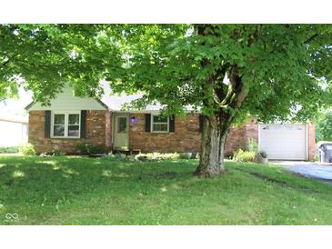 Charming brick home with a well-manicured lawn and mature tree offering ample shade at 515 Hawthorne Ave, Anderson, IN 46011