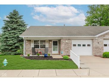 Charming brick home featuring a manicured lawn and inviting front porch with rocking chairs at 5515 Gateridge Ln, Indianapolis, IN 46237