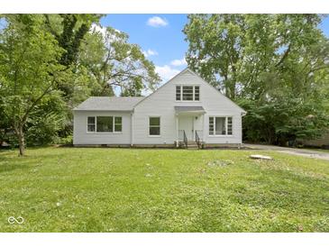 Charming white two-story home with a well-maintained front yard and surrounded by mature trees at 6833 Evanston Ave, Indianapolis, IN 46220