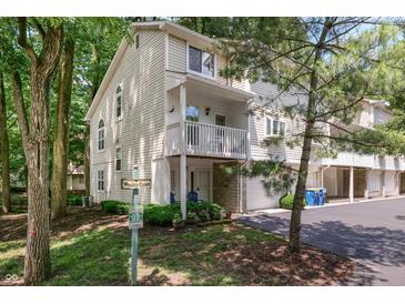 Attractive townhome with balcony, garage, and landscaping surrounded by mature trees at 6920 Wesley Ct, Indianapolis, IN 46220