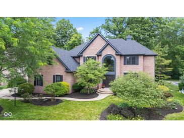 Beautiful brick home with a well-manicured lawn and mature trees offering shade at 11266 Old Stone Dr, Indianapolis, IN 46236