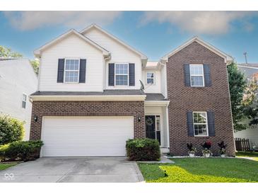 Charming two-story home featuring a brick and white exterior, attached two-car garage, and well-maintained landscaping at 13829 Black Canyon Ct, Fishers, IN 46038