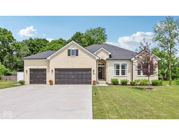 Charming, light brick home with a well-manicured lawn and an attached two-car garage at 14729 Erica Ln, Carmel, IN 46033
