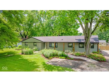 Charming single-story home featuring a well-manicured lawn and a beautiful garden at 1605 Westlane Rd, Indianapolis, IN 46260