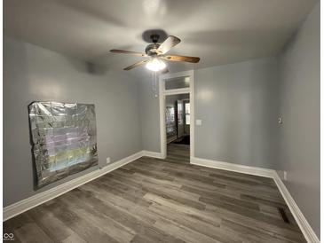 Bright living room featuring light grey walls, modern floors, ceiling fan, and lots of natural light at 3127 E Lynn St, Anderson, IN 46016