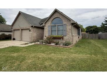 Charming brick home featuring an attached two-car garage and manicured lawn at 3327 Boxwood Dr, Indianapolis, IN 46227