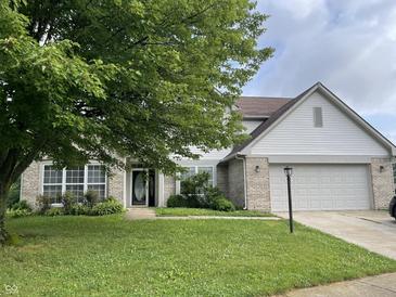 Charming two-story home with a well-manicured lawn, attached two-car garage, and lush landscaping at 3610 Homestead Pl, Plainfield, IN 46168