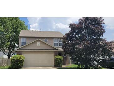 Traditional two-story home with vinyl siding and attached garage, surrounded by mature trees on a sunny day at 403 Bagley Ln, Indianapolis, IN 46231