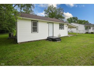 Back exterior view of home with white siding and green grass at 523 Patterson Rd, Columbus, IN 47203