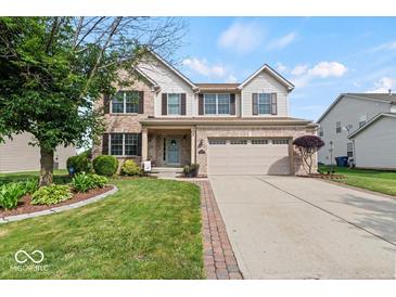 Charming two-story home with brick facade, two-car garage, manicured lawn, and beautiful landscaping at 5960 Dado Dr, Noblesville, IN 46062