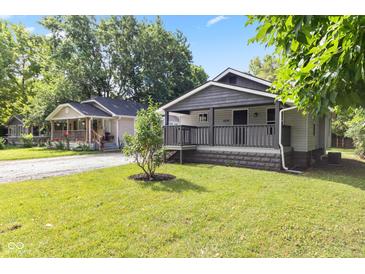 Charming home with inviting front yard and two-tone neutral color scheme at 6029 English Ave, Indianapolis, IN 46219