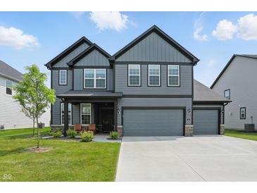 Two-story home with grey siding, a two car garage and a well manicured front lawn at 633 Cowley Dr, Westfield, IN 46074