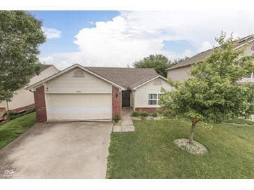 Charming home featuring a manicured front yard with a lush green lawn and mature tree at 11117 Waterfield Pl, Indianapolis, IN 46235