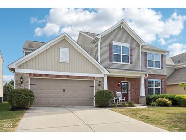 Two story home featuring brick and siding with a two car garage and manicured lawn at 14453 Glapthorn Rd, Fishers, IN 46037