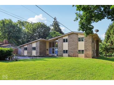 Charming brick home boasts a well-manicured lawn and mature trees at 3265 Tulip Dr, Indianapolis, IN 46227