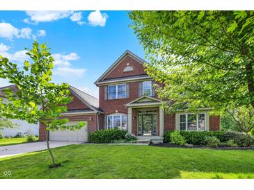 Beautiful two-story brick home with a manicured lawn and lush landscaping at 3740 Weather Stone Xing, Zionsville, IN 46077