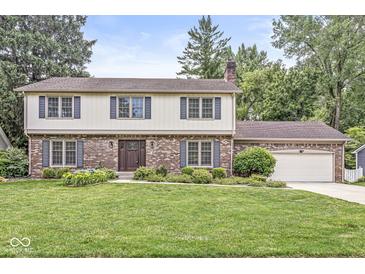 Charming brick and siding home with a well-manicured lawn and beautiful landscaping at 4431 Cranbrook Dr, Indianapolis, IN 46250