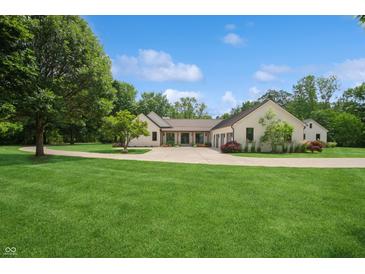 Stunning single-story home featuring a manicured lawn, circular driveway, and elegant architectural design at 6115 Stonegate Run, Zionsville, IN 46077