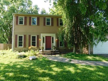 Charming two-story home featuring classic siding, a welcoming red front door, and well-maintained landscaping at 8425 E 82Nd E St, Indianapolis, IN 46256