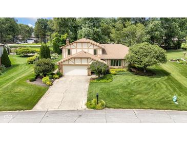Charming two-story home with a well-maintained lawn and beautiful landscaping at 8525 Winding Ridge Rd, Indianapolis, IN 46217