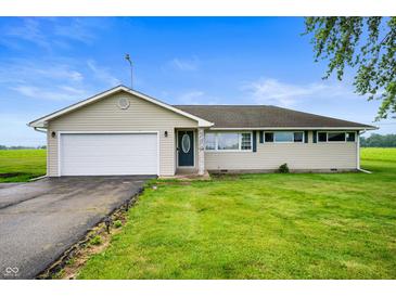 Charming single-story home with attached garage, lush lawn, and a welcoming front entrance at 10500 S County Road 200 W, Muncie, IN 47302