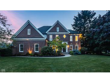 Charming two-story brick home with a well-manicured lawn, landscaping, and inviting front entrance at 15920 Oak Park Ct, Westfield, IN 46074