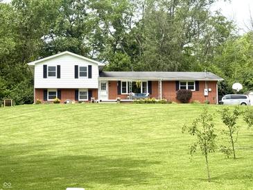 Charming two-story home with brick accents, white siding and black shutters on a large lawn at 2615 Alexandria Pike, Anderson, IN 46012