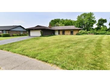 Charming single-story home with a brick and wood exterior, attached garage, and a well-manicured lawn at 6851 Azalea Dr, Indianapolis, IN 46214