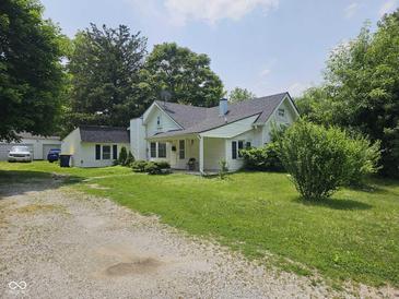 Charming home featuring a spacious front yard and white exterior with a cozy porch at 7831 E 46Th St, Indianapolis, IN 46226