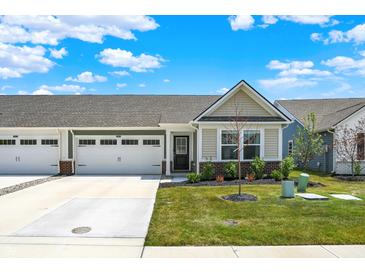 Inviting single-story home featuring an attached two-car garage and meticulously maintained front yard landscaping at 843 Garrow Dr, Westfield, IN 46074