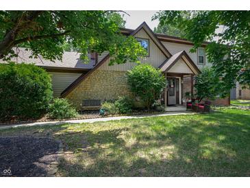 Charming two-story home featuring stone accents, a well-manicured lawn, and inviting front porch with seating at 919 Dreamy St, Greenwood, IN 46142
