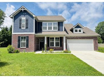 Charming two-story home featuring a brick and blue wood facade, with a well-manicured lawn at 980 S Raylee Garden Dr, New Palestine, IN 46163