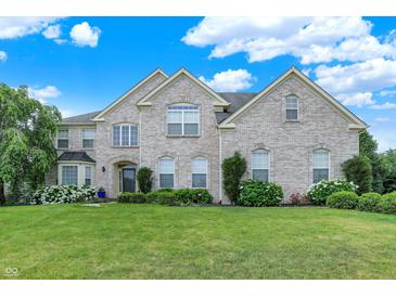 Charming two-story brick home with a lush green lawn, mature trees, and blooming hydrangeas at 10587 Proposal Pointe Way, Fishers, IN 46040