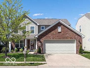 Charming two-story home featuring a brick front, two-car garage, and well-manicured lawn at 12584 Cold Stream Rd, Noblesville, IN 46060