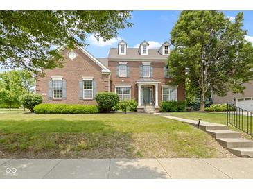 Charming two-story brick home with manicured lawn, mature trees, and classic architectural details at 13624 Alston Dr, Fishers, IN 46037