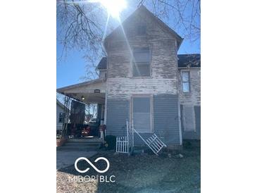 Two-story home with faded paint and a small front porch at 2519 N A St, Elwood, IN 46036