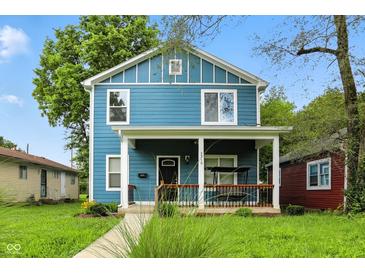 Charming two-story home with a welcoming front porch and a swing for relaxing, and manicured front lawn at 3210 Hovey St, Indianapolis, IN 46218