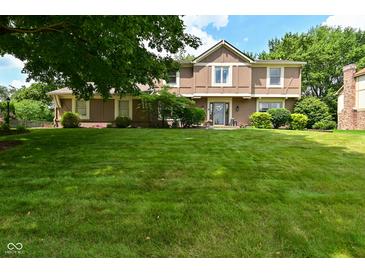 Traditional two-story home featuring a well-manicured lawn and lush landscaping in a suburban neighborhood at 4585 Abbey Dr, Carmel, IN 46033