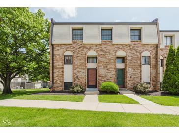 Brick townhome with well-maintained lawn and sidewalk leading to the front doors at 49 Druid Hill Ct # 0, Carmel, IN 46032