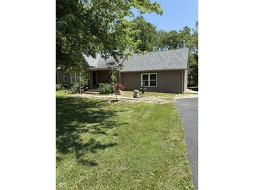 Charming brick home featuring a well-maintained lawn, mature trees, and decorative fountain, blending comfort with natural beauty at 9168 S State Road 9, Flat Rock, IN 47234