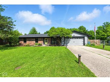 Charming single-story home featuring brick accents, an attached garage, and a well-maintained front yard at 9265 Brunson Run, Indianapolis, IN 46256