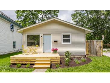 Charming home featuring a newly built deck with light blue door, and verdant landscaping at 946 N Temple Ave, Indianapolis, IN 46201