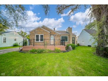 Charming stone-accented home featuring a cozy front porch and a well-maintained green lawn at 171 Nursery Rd, Anderson, IN 46012