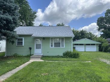 Charming single story home with a well-maintained lawn and detached two car garage in backyard at 2473 N Goodlet Ave, Indianapolis, IN 46222