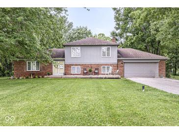 Charming home featuring a spacious lawn, a welcoming front porch, and an attached two-car garage at 3090 N County Road 800 E Rd, Brownsburg, IN 46112