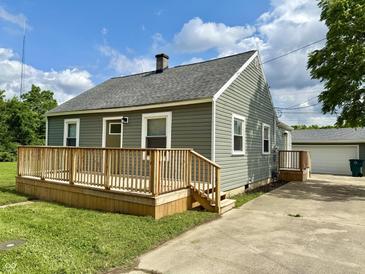 Charming home featuring a spacious front deck, well-maintained siding, and a detached garage at 405 E Cowing Dr, Muncie, IN 47303